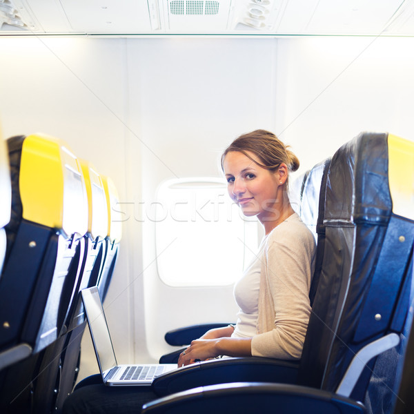 Fiatal nő tábla dolgozik laptop számítógép repülőgép számítógép Stock fotó © lightpoet