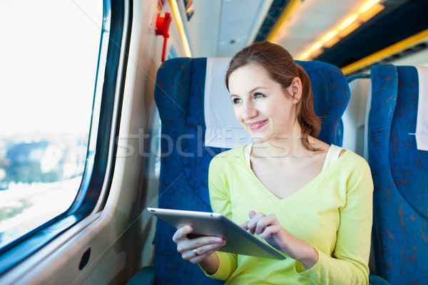 Young woman using her tablet computer while traveling by train  Stock photo © lightpoet
