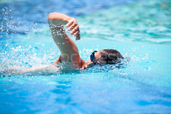 Young man swimming the front crawl in a pool Stock photo © lightpoet