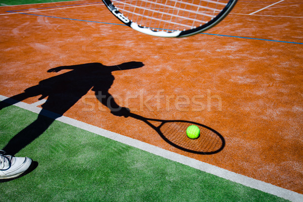 Stock photo: shadow of a tennis player in action on a tennis court