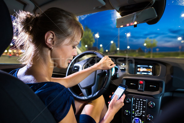  Pretty, young woman driving her modern car at night, in a city Stock photo © lightpoet