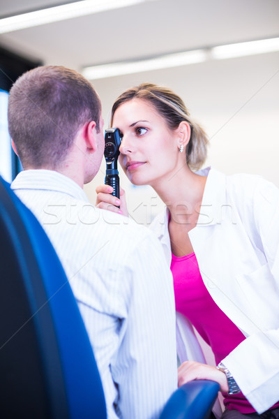 Stock photo: Handsome young man having his eyes examined by an eye doctor