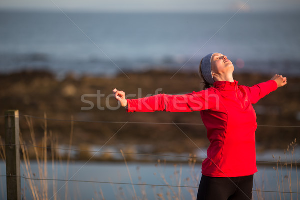 Stock photo: Young woman on her evening jog along the seacoast