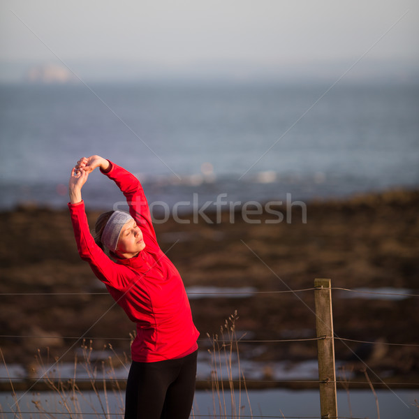 Stock photo: Young woman on her evening jog along the seacoast