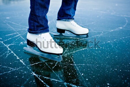 Stock photo: Young woman ice skating outdoors on a pond on a freezing winter 