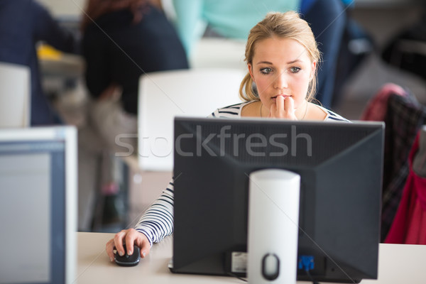 Pretty, female student looking at a desktop computer screen Stock photo © lightpoet