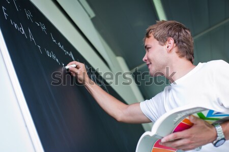 Handsome college student solving a math problem  Stock photo © lightpoet