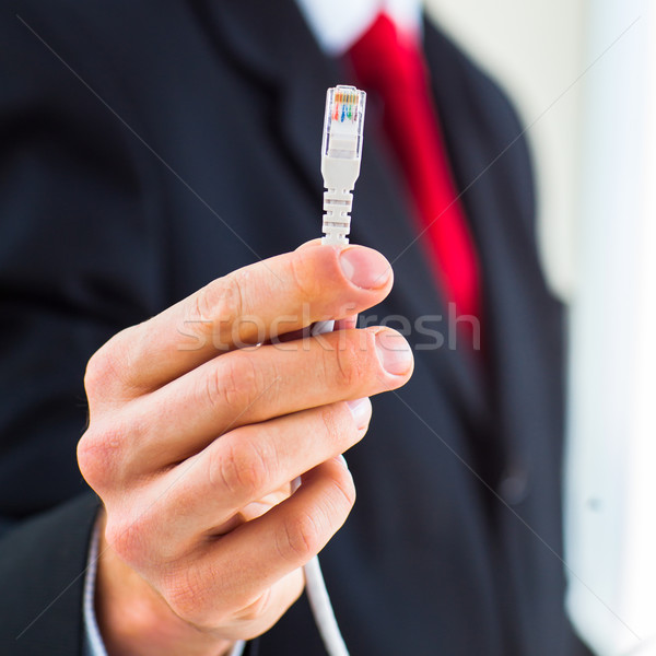 Fiatal üzletember tart ethernet kábel jelentőség Stock fotó © lightpoet