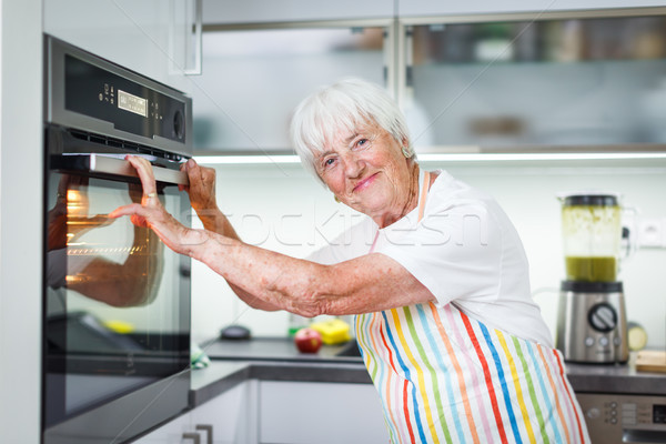 Senior femeie gătit bucătărie mananca sănătos Imagine de stoc © lightpoet
