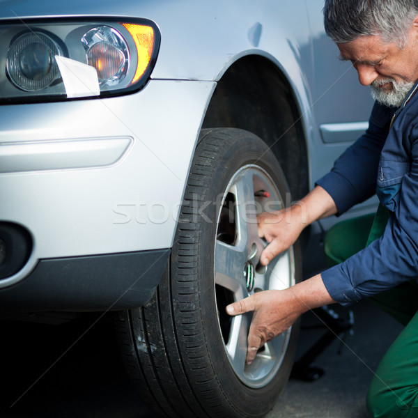 Stock photo: mechanic changing a wheel of a modern car 