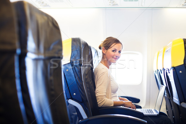 Mulher jovem conselho trabalhando computador portátil avião computador Foto stock © lightpoet