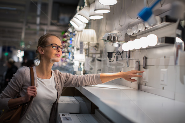 Pretty, young woman choosing the right light for her appartment  Stock photo © lightpoet