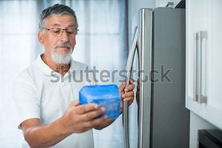 Is this still fine? Senior man in his kitchen  looking at the expiry date  Stock photo © lightpoet