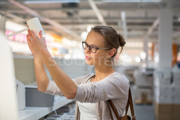 Pretty, young woman choosing the right light for her appartment  Stock photo © lightpoet