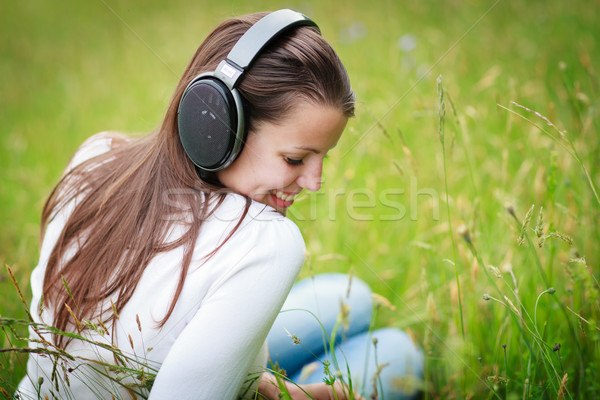 portrait of a pretty young woman listening to music Stock photo © lightpoet