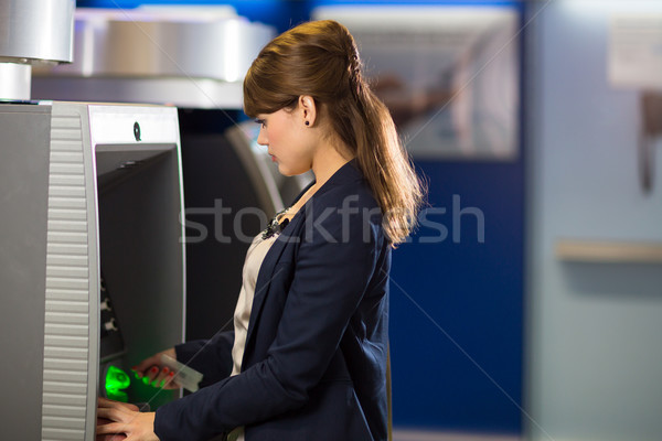 Pretty, young woman withdrawing money from her credit card Stock photo © lightpoet
