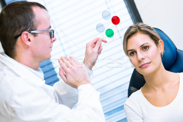 Hhandsome young man having his eyes examined by an eye doctor Stock photo © lightpoet