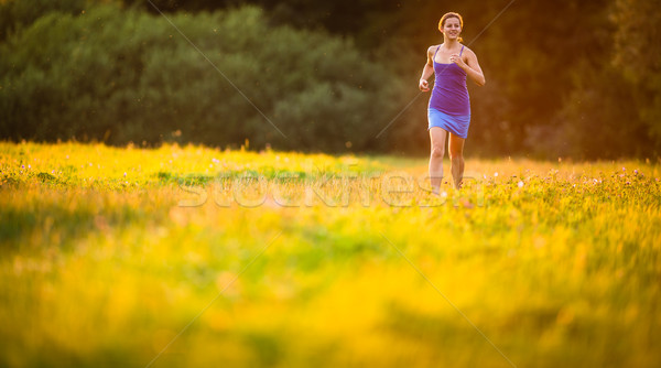 Young woman running outdoors on a lovely sunny summer evening (s Stock photo © lightpoet