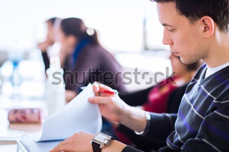 Stock photo: young, handsome male college student sitting in a classroom