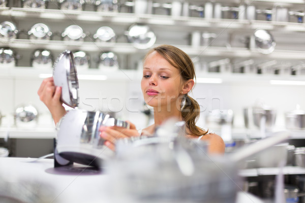 Pretty, young woman choosing a the right pot Stock photo © lightpoet