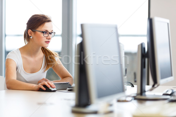 Stock photo: Pretty, female student looking at a desktop computer screen