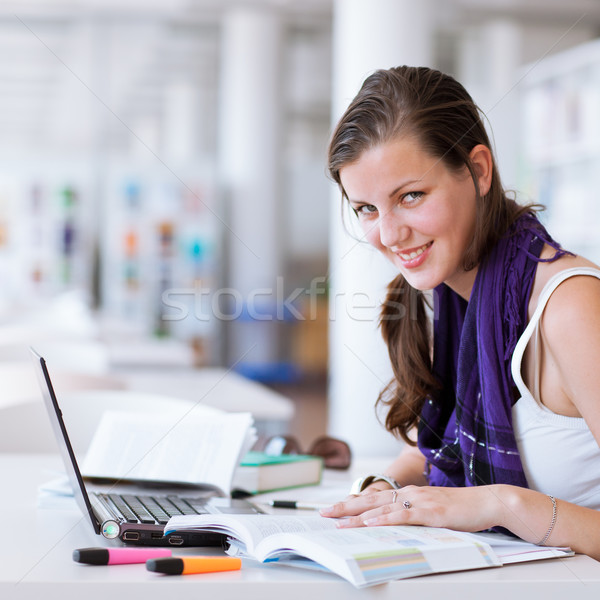 Stock photo: pretty female college student studying in the university library
