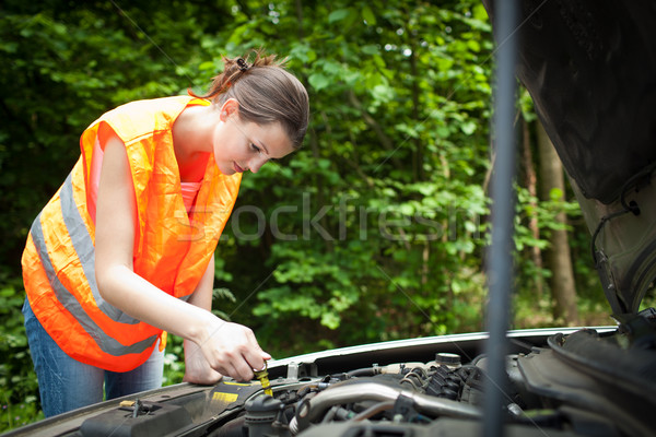 Young female driver bending over  the engine of her broken down car Stock photo © lightpoet