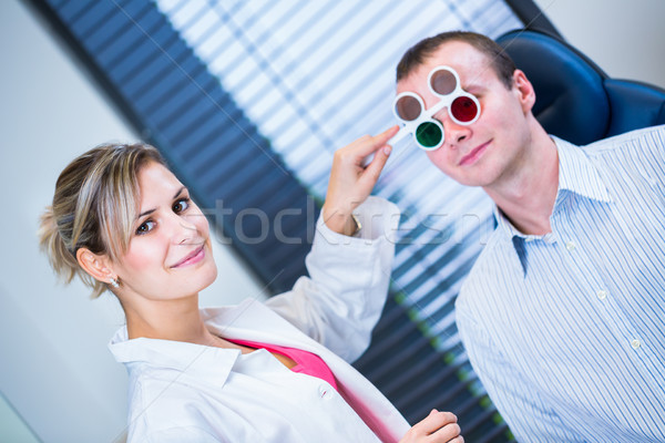 Hhandsome young man having his eyes examined by an eye doctor Stock photo © lightpoet