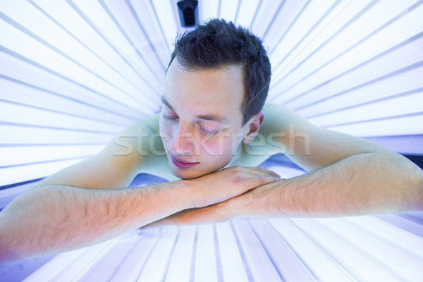 Handsome young man relaxing during a tanning session Stock photo © lightpoet