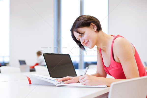 Pretty young college student studying in the library Stock photo © lightpoet