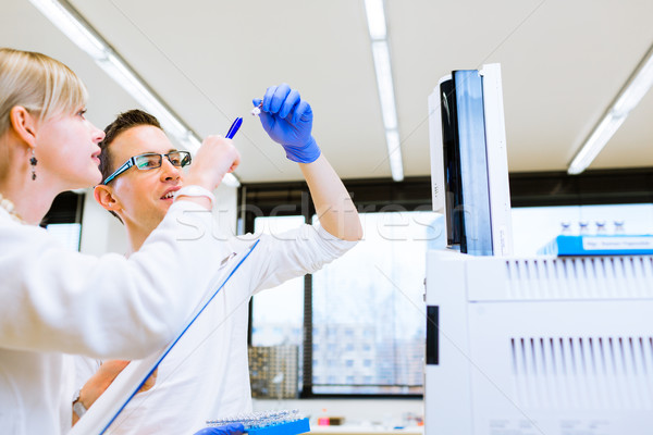 Stock photo: Two young researchers carrying out experiments in a lab