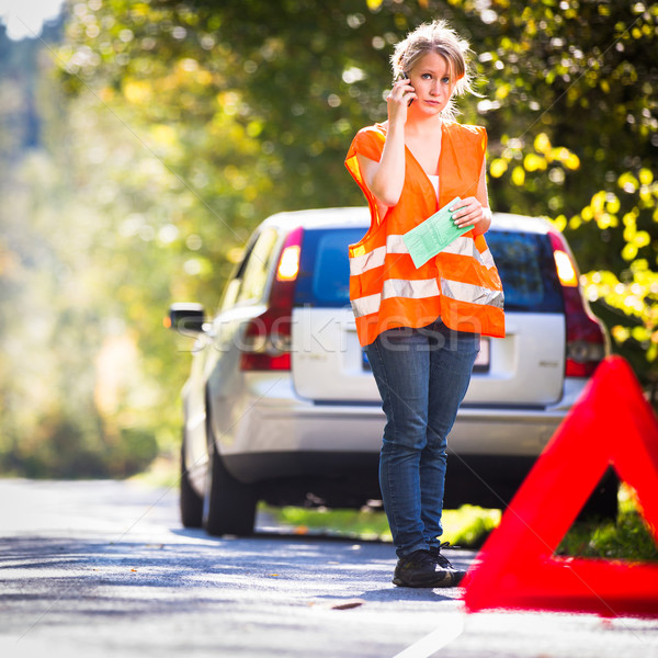 Young female driver wearing a high visibility vest, calling the  Stock photo © lightpoet