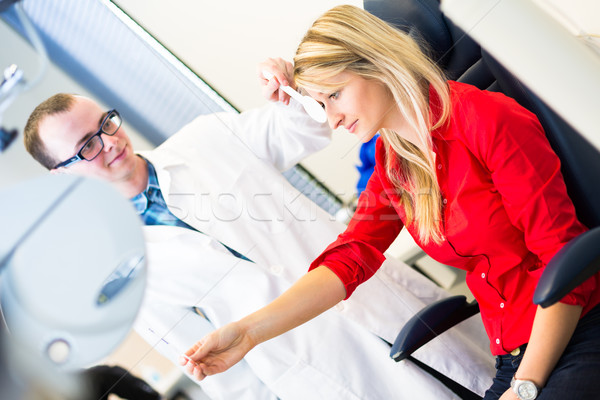 Stock photo: Optometry concept - pretty young woman having her eyes examined 
