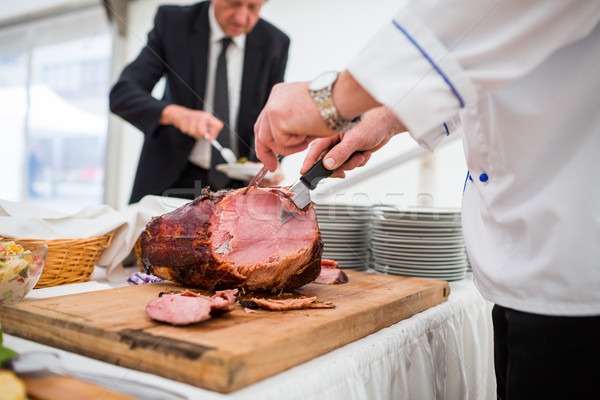 Catering service employee cutting ham Stock photo © lightpoet