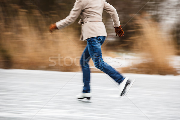 Stock photo: Young woman ice skating outdoors on a pond 