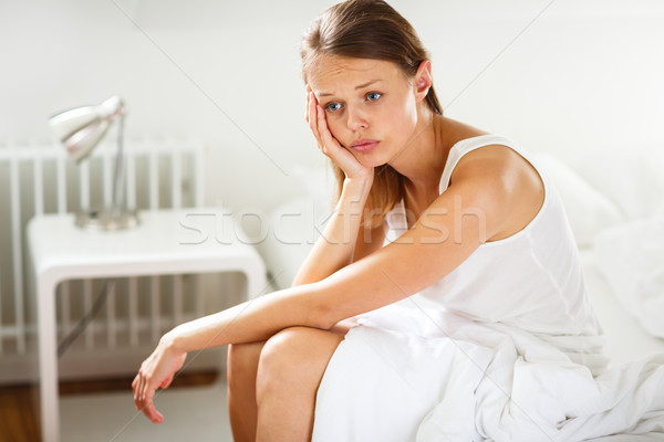 Csinos fiatal nő ül ágy néz boldogtalan Stock fotó © lightpoet