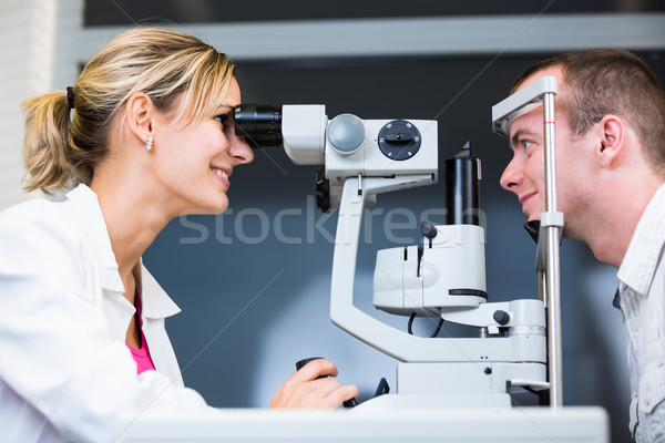 optometry concept - handsome young man having her eyes examined  Stock photo © lightpoet