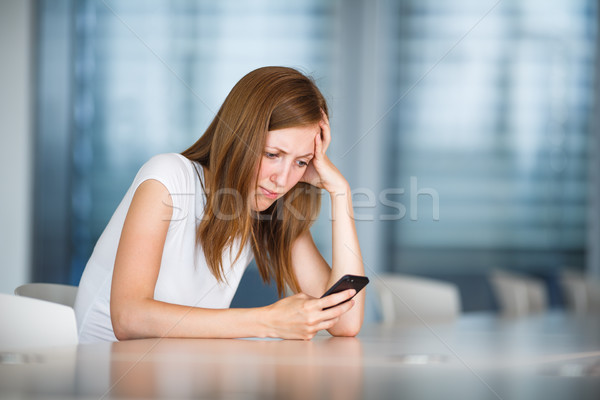 Depressed/anxious/unhappy young woman using her smart phone Stock photo © lightpoet