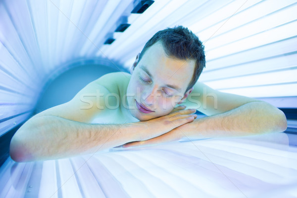 Przystojny młody człowiek relaks nowoczesne solarium Zdjęcia stock © lightpoet