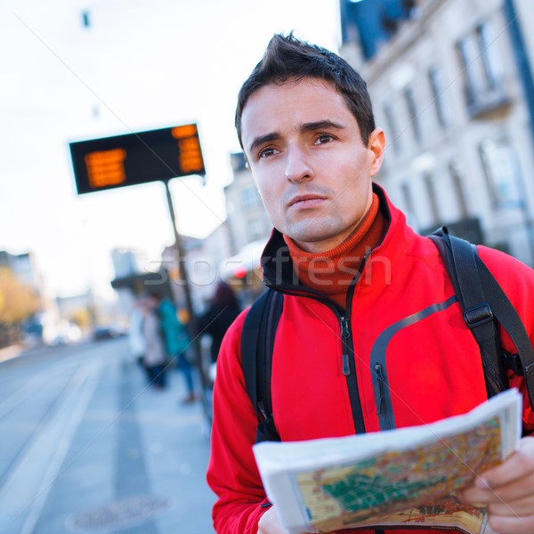 Just arrived: handsome young man studying a map on a bus stop Stock photo © lightpoet