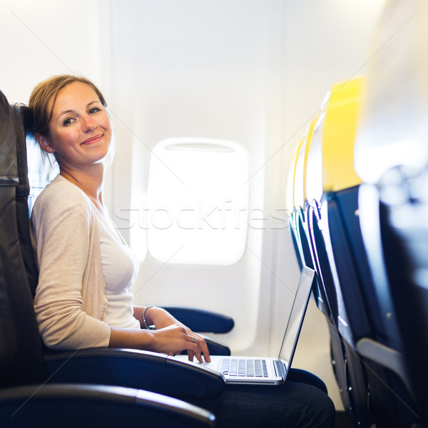Jeune femme bord travail ordinateur portable avion ordinateur [[stock_photo]] © lightpoet