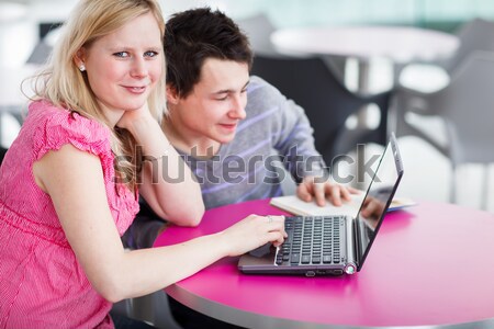 Two college students having fun studying together, using a lapto Stock photo © lightpoet
