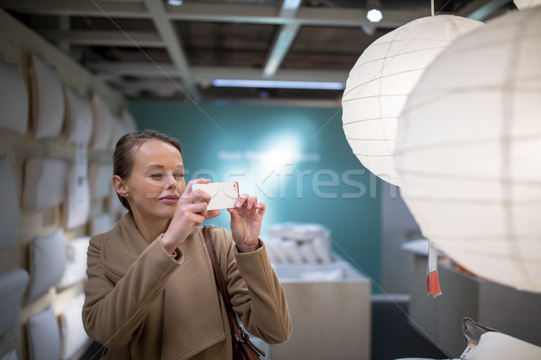 Pretty, young woman choosing the right lamp  Stock photo © lightpoet