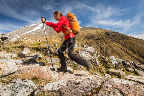 Stock photo: Pretty, young female hiker going uphill