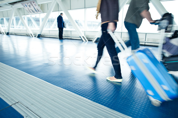 Stock photo: People with their suitcases walking along a corridor