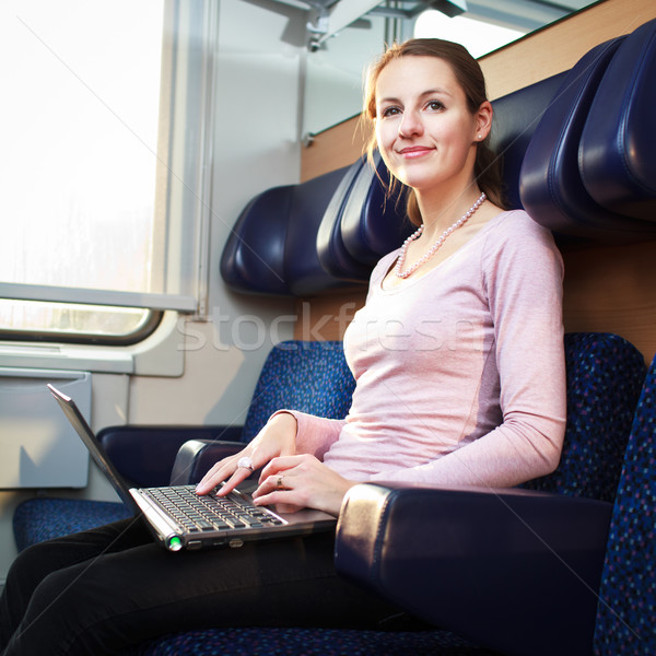 Young woman using her laptop computer while on the train  Stock photo © lightpoet