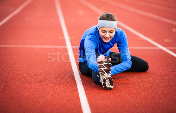 Stock photo: Young woman stretching before her run
