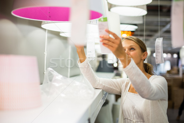 Pretty, young woman choosing the right light for her apartment Stock photo © lightpoet