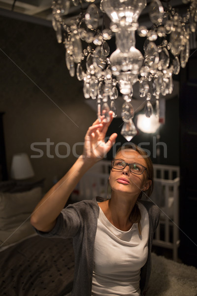 Pretty, young woman choosing the right chandelier Stock photo © lightpoet