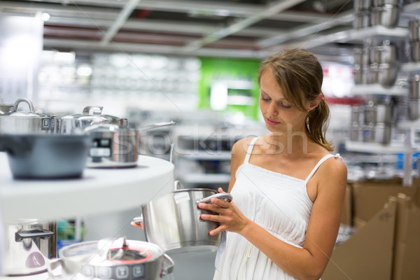 Pretty, young woman choosing a the right pot Stock photo © lightpoet